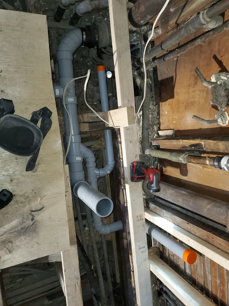 Grey PVC drain and vent pipes installed during a renovation